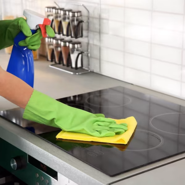 woman-cleaning-stove-kitchen_392895-535012